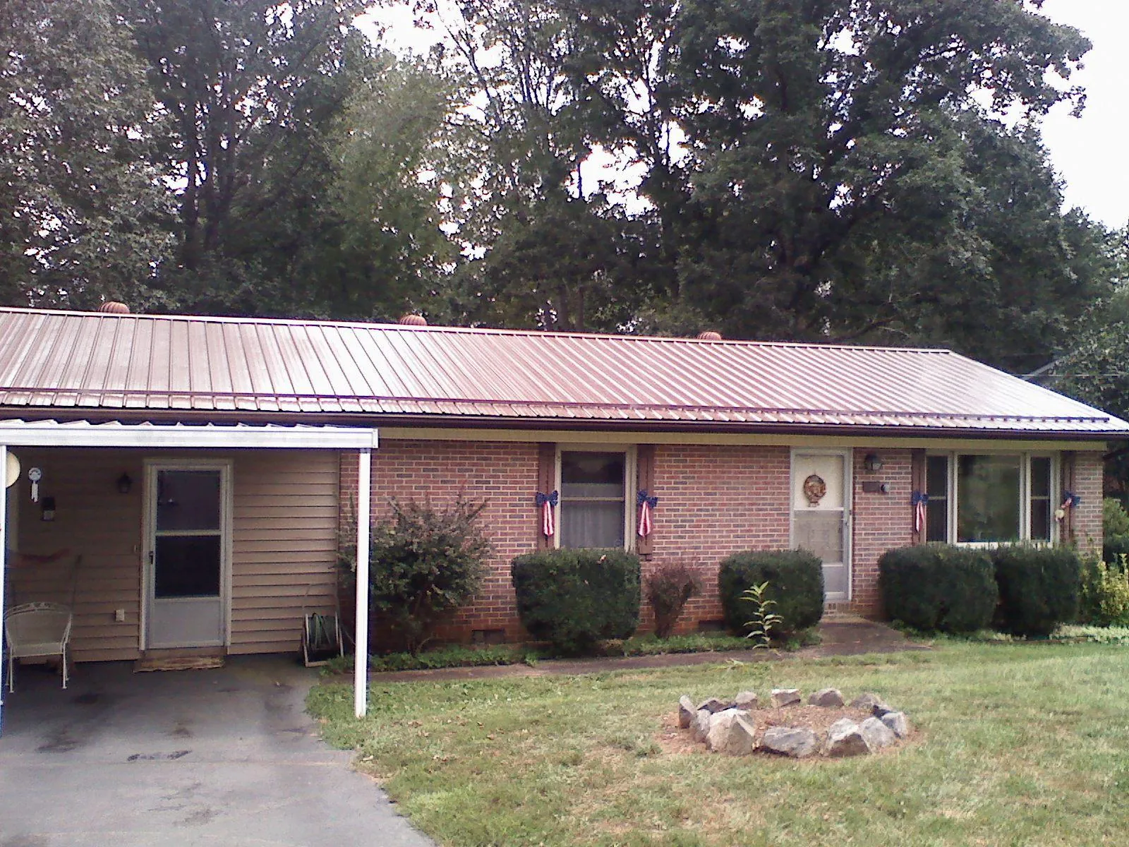 Bronze metal roof and carport on a brick ranch home — Roof Repair work by our crew in Milnor